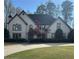 Charming home with manicured lawn, mature trees, and a traditional facade with beautiful windows at 9290 Prestwick Club Dr, Johns Creek, GA 30097