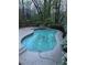 Backyard swimming pool featuring a unique shape, a tiled border, and surrounded by a concrete patio at 9290 Prestwick Club Dr, Johns Creek, GA 30097