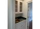Wet bar with glass shelves, granite counters, and brass sink basin at 9290 Prestwick Club Dr, Johns Creek, GA 30097
