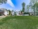 Spacious backyard featuring a lush green lawn, mature trees, and a white fence surrounding the property at 140 N Lakeside Nw Dr, Kennesaw, GA 30144