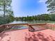 Spacious wooden deck overlooking a sparkling in-ground pool and scenic lake view, ideal for outdoor entertaining at 140 N Lakeside Nw Dr, Kennesaw, GA 30144