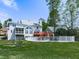 Back of house showcasing a pool, lake view, deck, screened porch, and manicured lawn at 140 N Lakeside Nw Dr, Kennesaw, GA 30144