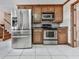 Kitchen featuring stainless steel appliances, wood cabinets, and tile flooring at 140 N Lakeside Nw Dr, Kennesaw, GA 30144