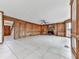 Cozy living room featuring a stone fireplace, wood paneling, and tile flooring throughout at 140 N Lakeside Nw Dr, Kennesaw, GA 30144