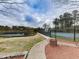 Well-maintained tennis courts within a fenced area, surrounded by trees and landscaping at 140 N Lakeside Nw Dr, Kennesaw, GA 30144