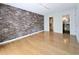 Bedroom featuring a brick wall, gleaming hardwood floors, and direct access to a bathroom and walk-in closet at 1490 N Crossing Circle Ne Cir # 1490, Atlanta, GA 30329