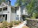 Well-maintained townhouse with a covered front porch, stone exterior wall, landscaped yard, and ample natural light at 1490 N Crossing Circle Ne Cir # 1490, Atlanta, GA 30329