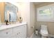 Bathroom features a modern vanity with a marble countertop, stylish fixtures, and a window at 2724 Parkwood Se Rd, Smyrna, GA 30080