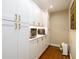 Walk-in pantry features built-in shelves, white cabinets with gold hardware, and hardwood floors at 2724 Parkwood Se Rd, Smyrna, GA 30080