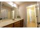 Bathroom with a white sink, a large mirror, and a door leading to a bathtub and toilet at 3880 Deer Run Dr, Cumming, GA 30028