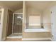 Bright bathroom featuring a glass enclosed shower and soaking tub at 3880 Deer Run Dr, Cumming, GA 30028