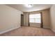 A well-lit bedroom featuring neutral walls, carpet flooring, and window with patterned curtains at 3880 Deer Run Dr, Cumming, GA 30028