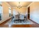 Elegant dining room with a chandelier, large windows, and seating for six at 3880 Deer Run Dr, Cumming, GA 30028