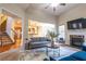 Bright living room boasts fireplace, ceiling fan and transitions to kitchen and stairwell at 3880 Deer Run Dr, Cumming, GA 30028