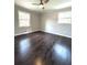Bright bedroom features hardwood floors, ceiling fan, and two windows for natural light at 6125 Connell Rd, Atlanta, GA 30349