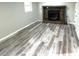 Living room featuring a stone fireplace and gray, wood-look flooring at 6125 Connell Rd, Atlanta, GA 30349