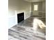 Bright living room featuring light wood-style flooring, base trim and a fireplace at 6125 Connell Rd, Atlanta, GA 30349