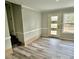 View of a living room with light wood-style flooring, base trim and natural light at 6125 Connell Rd, Atlanta, GA 30349