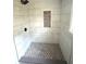 Modern tiled shower featuring gray floor tiles, a niche, and sleek fixtures at 6125 Connell Rd, Atlanta, GA 30349