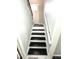 View of a staircase with black painted treads and white painted risers and handrail at 6125 Connell Rd, Atlanta, GA 30349