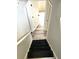 View of stairs with black risers leading to a doorway and gray wood-look flooring at 6125 Connell Rd, Atlanta, GA 30349