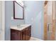 Bathroom featuring a vanity with a countertop, wood cabinets, a mirror, and a glass-door shower at 650 Ira Sw St, Atlanta, GA 30312