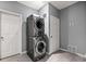 Laundry room featuring gray walls, tiled floors, and modern stacked washer and dryer at 650 Ira Sw St, Atlanta, GA 30312