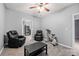 Living room featuring neutral walls, ceiling fan, exercise bike, comfy recliners, black sofa, and tiled floor at 650 Ira Sw St, Atlanta, GA 30312