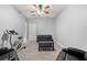Living room featuring neutral walls, ceiling fan, exercise bike, comfy recliners, black sofa, and tiled floor at 650 Ira Sw St, Atlanta, GA 30312