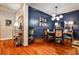 Elegant dining room featuring dark blue accent wall, modern lighting, and hardwood floors at 2250 W Village Junction Se Way, Smyrna, GA 30080
