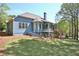 Backyard showing the screened porch and wooden deck with lush lawn and mature trees at 3015 Larkspur Ct, Cumming, GA 30041