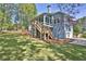 Landscaped backyard with wooden deck/stairs, lush lawn, and mature trees at 3015 Larkspur Ct, Cumming, GA 30041