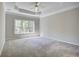 Spacious carpeted bedroom with tray ceilings, large window, and neutral decor at 3015 Larkspur Ct, Cumming, GA 30041
