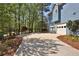 Long concrete driveway leading to a two-car garage surrounded by mature trees at 3015 Larkspur Ct, Cumming, GA 30041