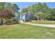 View of the home with a driveway leading to the two-car garage and lovely landscaping at 3015 Larkspur Ct, Cumming, GA 30041