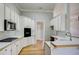 Well-lit kitchen featuring white cabinetry, tile backsplash, and wood countertops at 3015 Larkspur Ct, Cumming, GA 30041