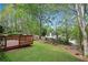 Beautifully maintained backyard with a deck overlooking a lush green space and mature trees at 3925 Tugaloo River Dr, Duluth, GA 30097
