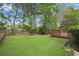 Spacious backyard with a lush lawn, mature trees, and wooden deck, perfect for outdoor entertaining at 3925 Tugaloo River Dr, Duluth, GA 30097