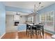 Bright dining area features hardwood floors, modern chandelier, and views into the cozy living room with fireplace at 3925 Tugaloo River Dr, Duluth, GA 30097