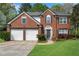 Charming two-story brick home with a well-manicured lawn and a two-car garage at 3925 Tugaloo River Dr, Duluth, GA 30097