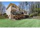 Exterior view of the house from backyard showing a lush green lawn, a privacy fence, mature trees, and deck at 4765 Karls Gate Dr, Marietta, GA 30068