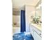Bathroom with blue rug, tub and shower combo, and white vanity with ample storage at 5401 Fox Creek Lane, Norcross, GA 30071