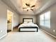 Large main bedroom with tray ceiling and fan, with adjoining bathroom to the left at 5401 Fox Creek Lane, Norcross, GA 30071
