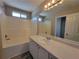 Bright bathroom featuring a white vanity, large mirror, tub-shower combo, and neutral wall color at 5820 Wellborn Oaks Ct, Lithonia, GA 30058