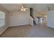 Spacious living room featuring neutral carpet, vaulted ceilings, a ceiling fan, and staircase at 5820 Wellborn Oaks Ct, Lithonia, GA 30058