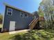 Exterior back view featuring gray siding, windows, a white door and a wooden deck with stairs at 234 Gamel Rd, Dallas, GA 30157