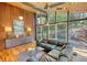 Well-lit living room featuring hardwood floors, a sleek sideboard, and expansive windows offering views of the lush surroundings at 151 Rockmart Dr Sw, Atlanta, GA 30314
