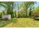 Spacious backyard featuring lush greenery, a storage shed, and a charming deck at 645 Camp Perrin Rd, Lawrenceville, GA 30043