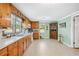 Well-lit kitchen featuring wood cabinets, white appliances, and an eat-in area at 645 Camp Perrin Rd, Lawrenceville, GA 30043