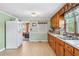 Spacious kitchen featuring wood cabinets, white appliances, and an opening to living area at 645 Camp Perrin Rd, Lawrenceville, GA 30043